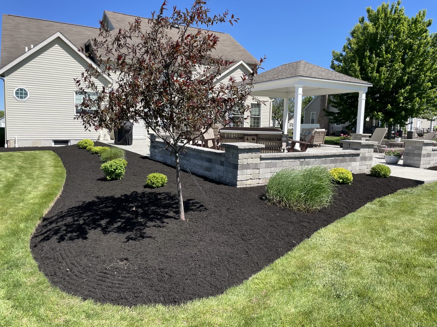 Colorful front-yard landscape with flowering shrubs and a manicured lawn