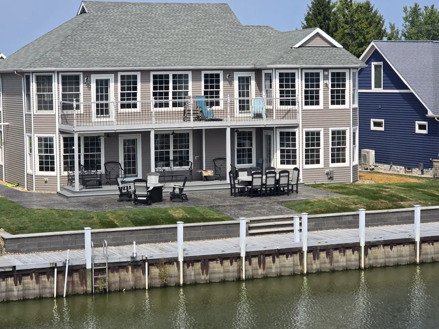 Completed waterfront landscape with a fresh lawn, retaining wall, and lakeside view