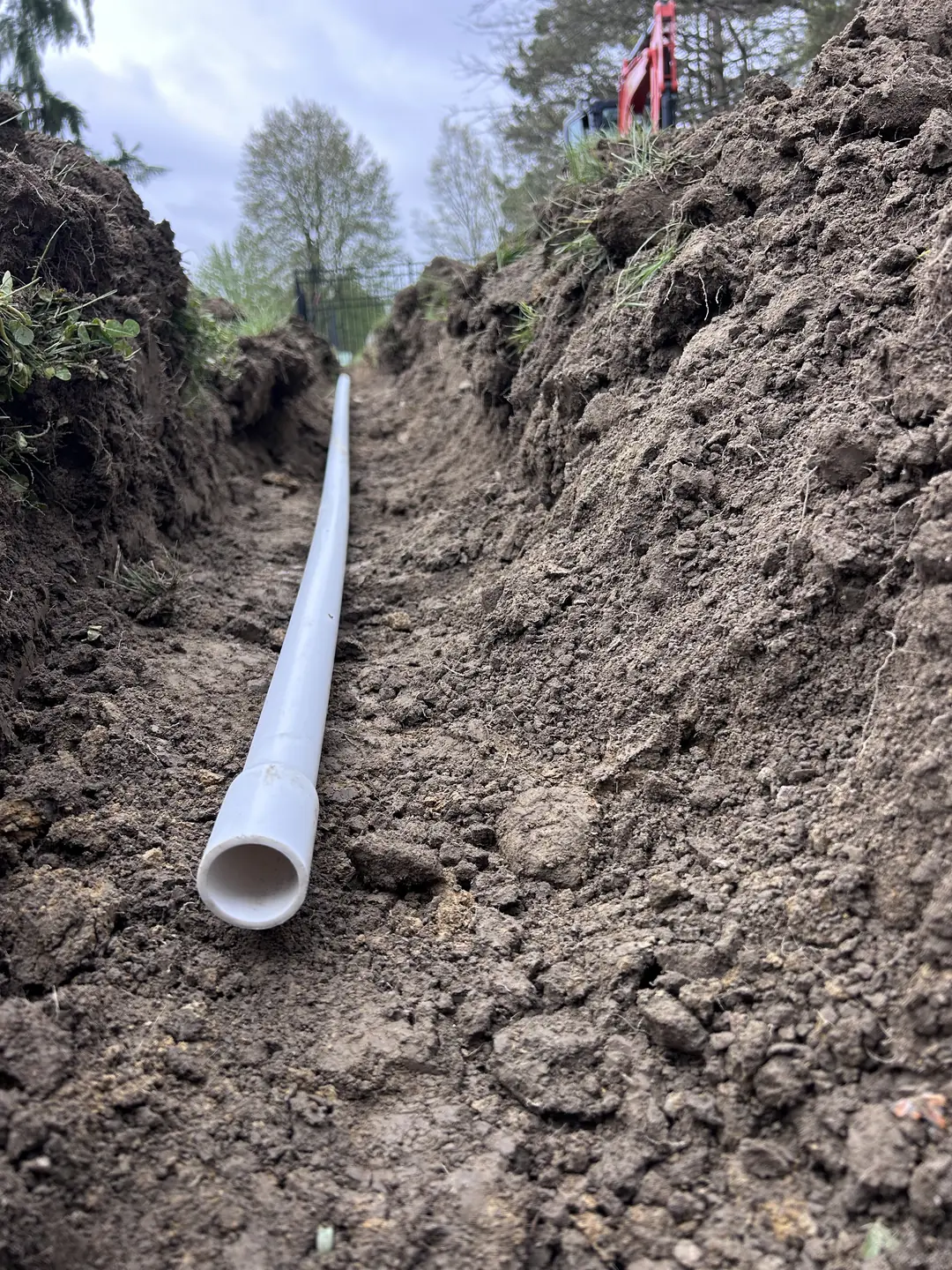 Drainage, excavation, and base preparation on an active job site