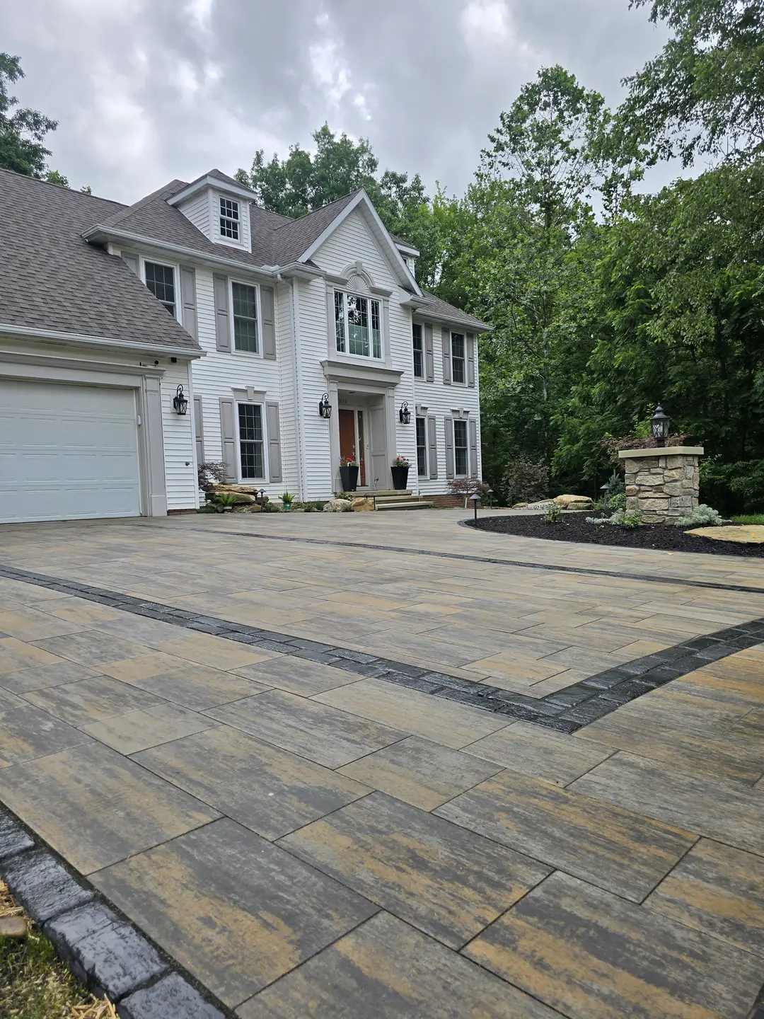 Finished paver driveway and landscaped front entry at a Stow property