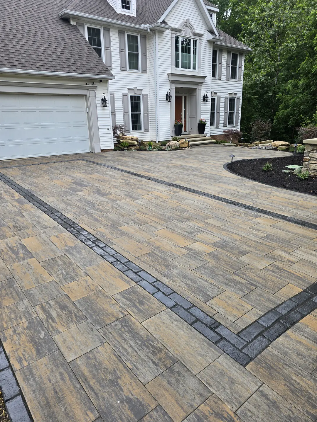 Finished paver driveway and landscaped front entry at a Stow property