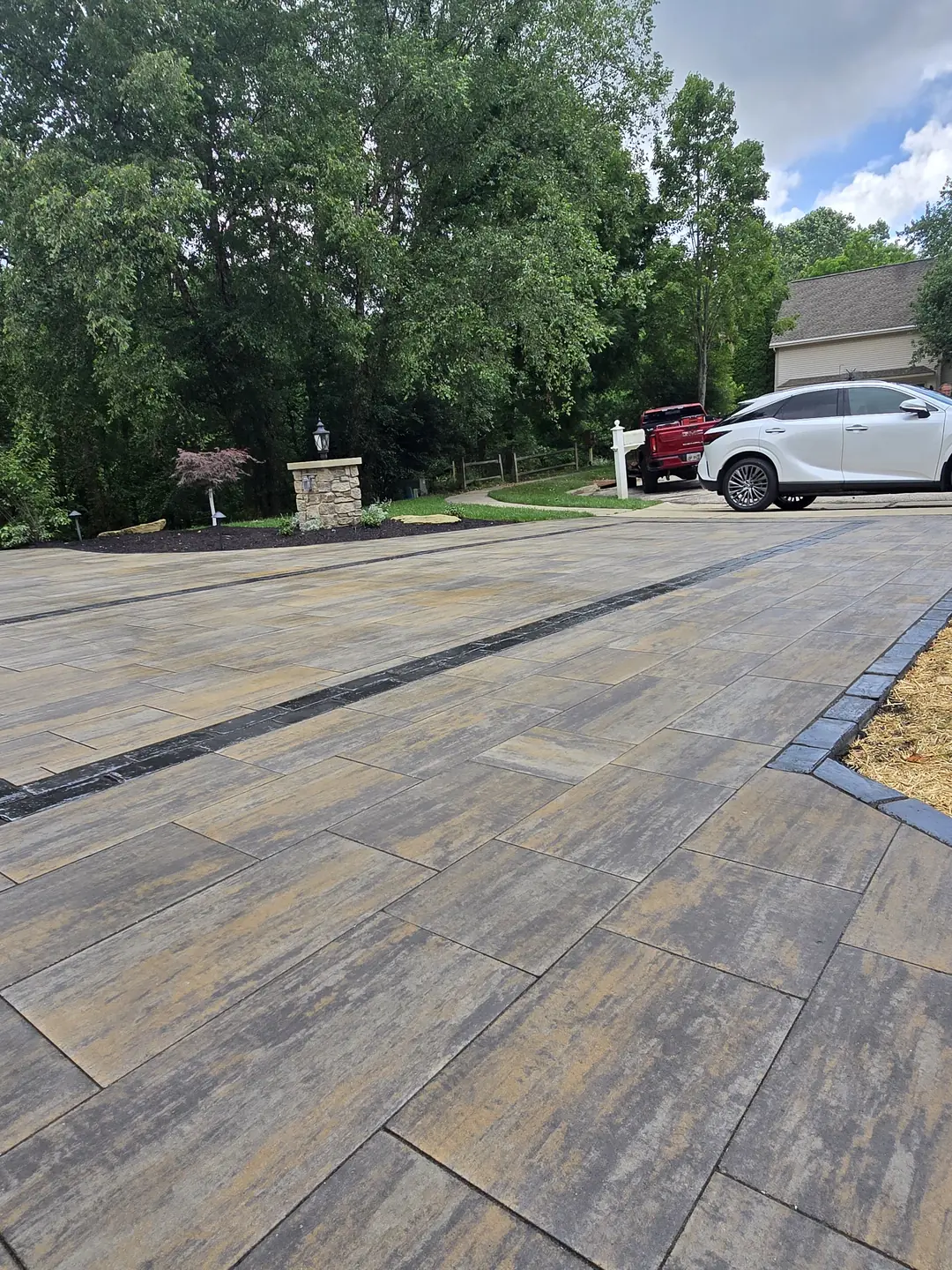 Finished paver driveway and landscaped front entry at a Stow property