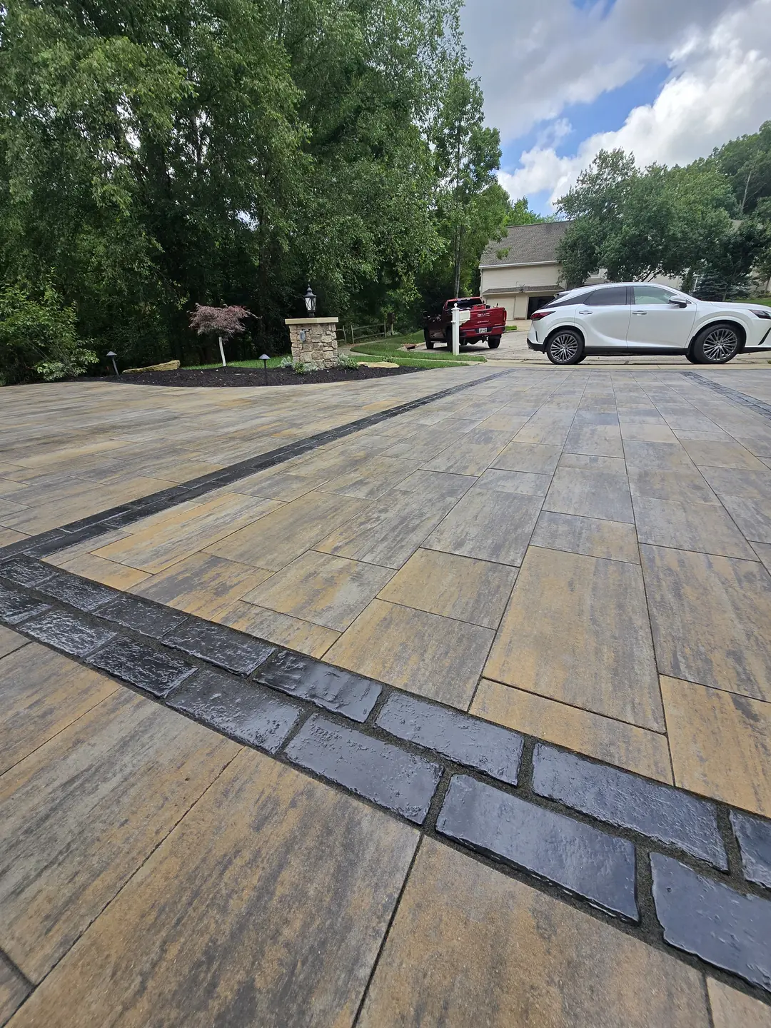 Finished paver driveway and landscaped front entry at a Stow property