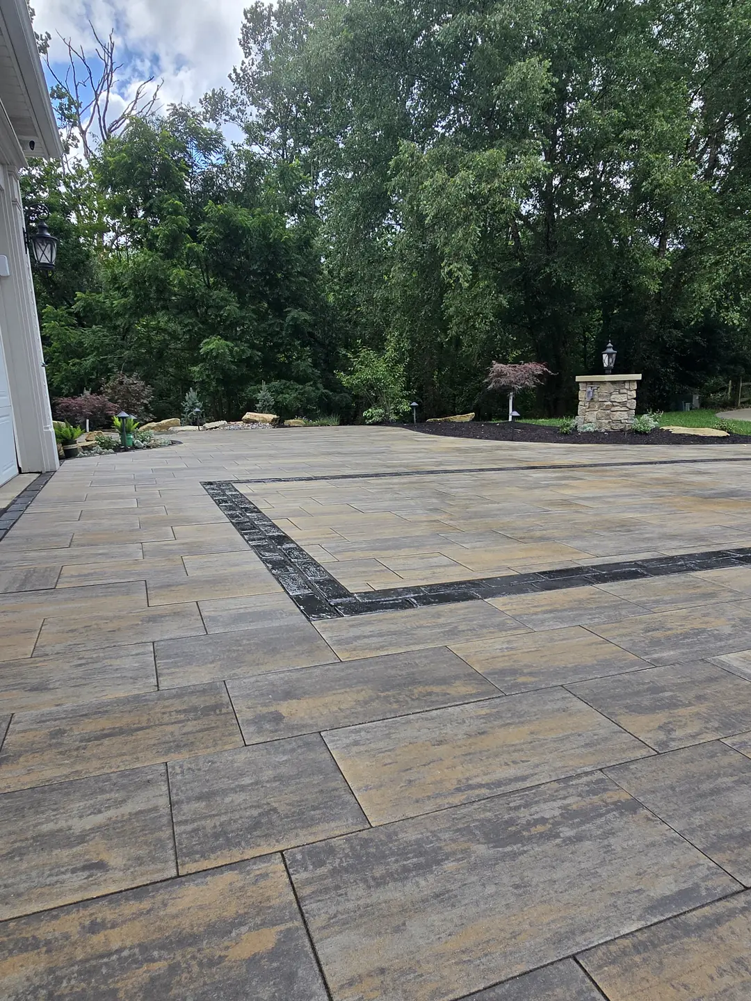 Finished paver driveway and landscaped front entry at a Stow property