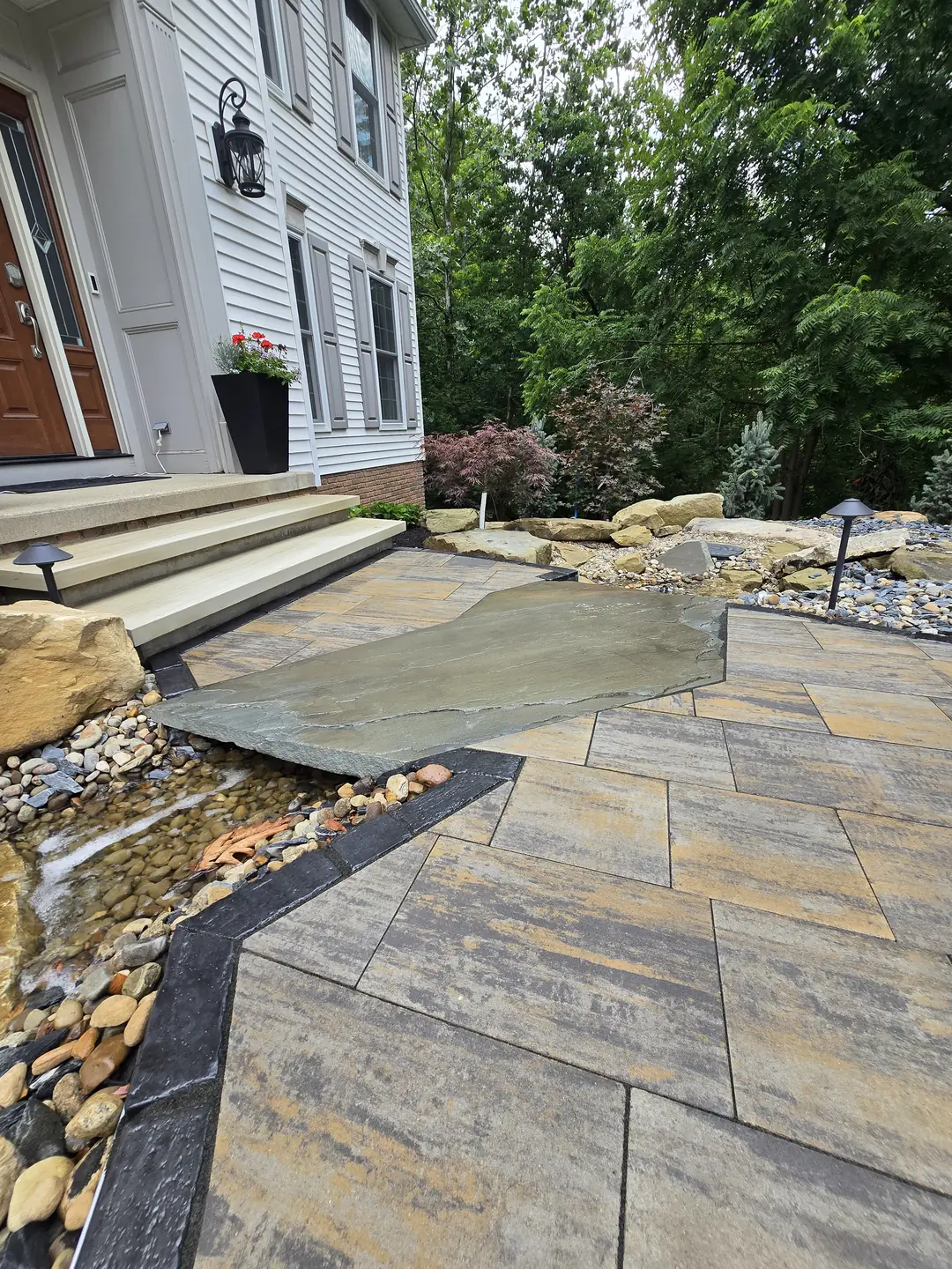 Finished paver driveway and landscaped front entry at a Stow property