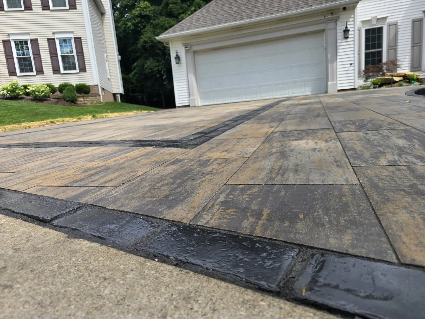 Finished paver driveway and landscaped front entry at a Stow property