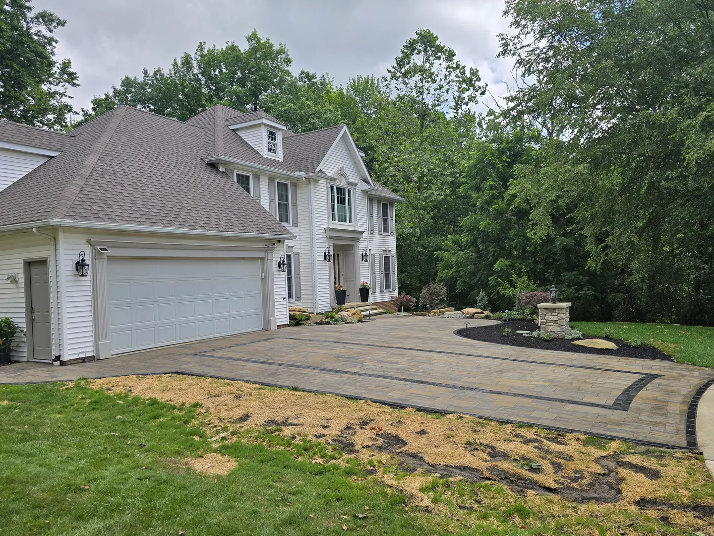 Finished paver driveway and landscaped front entry at a Stow property