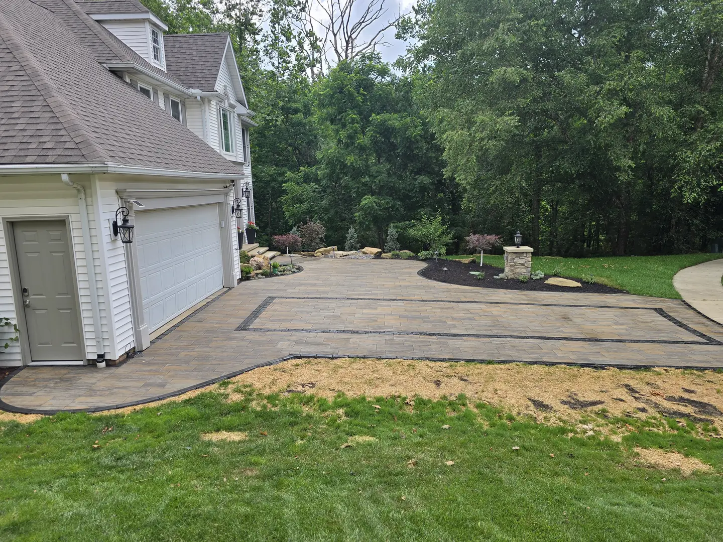 Finished paver driveway and landscaped front entry at a Stow property