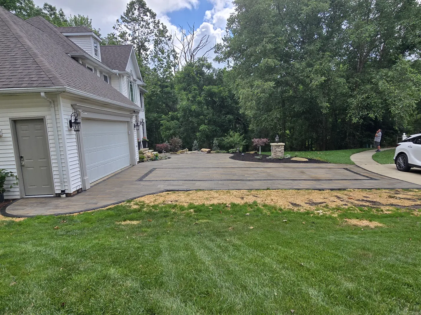 Finished paver driveway and landscaped front entry at a Stow property