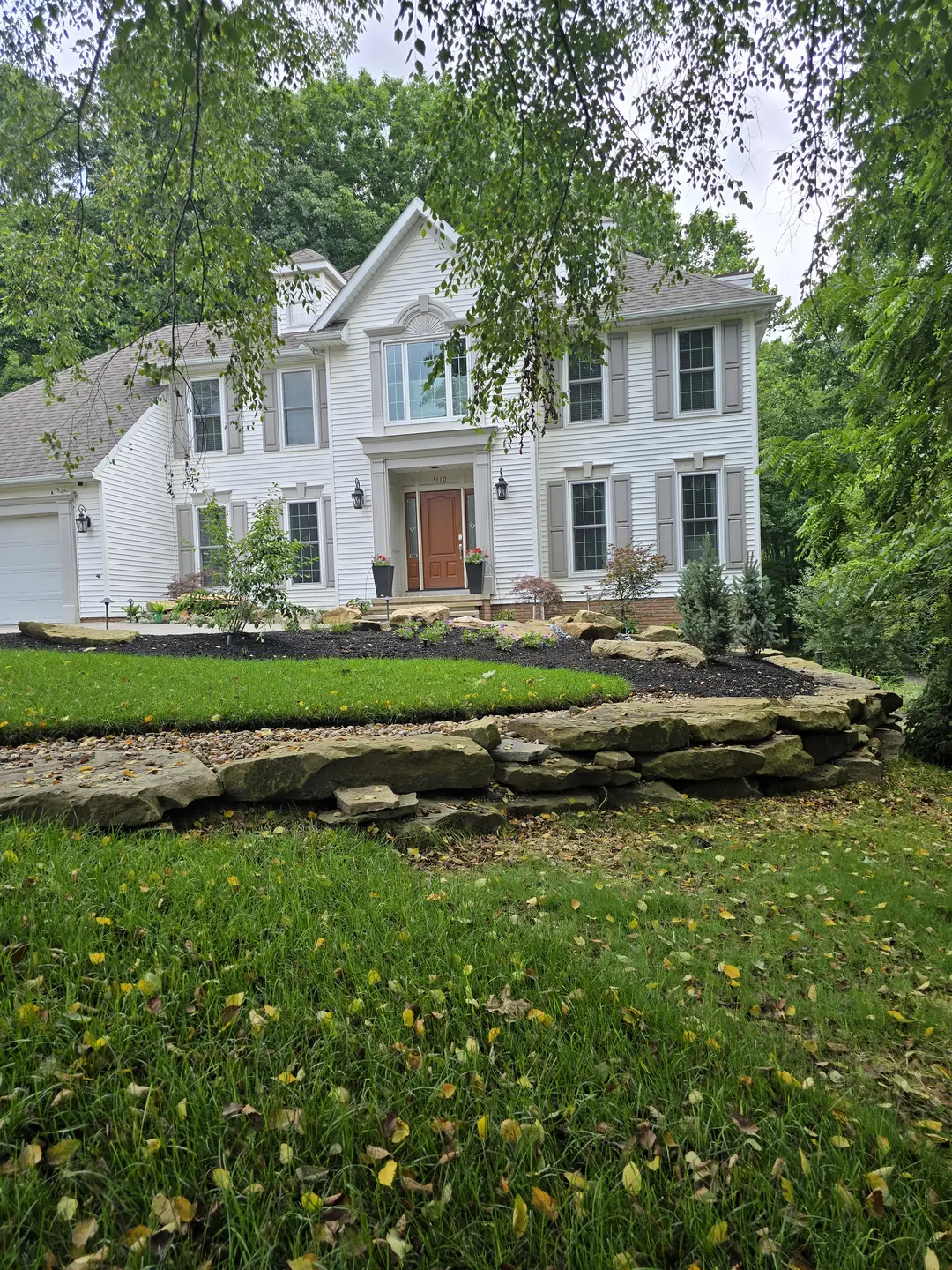 Completed Stow front landscape with natural stone, shrubs, and lighting