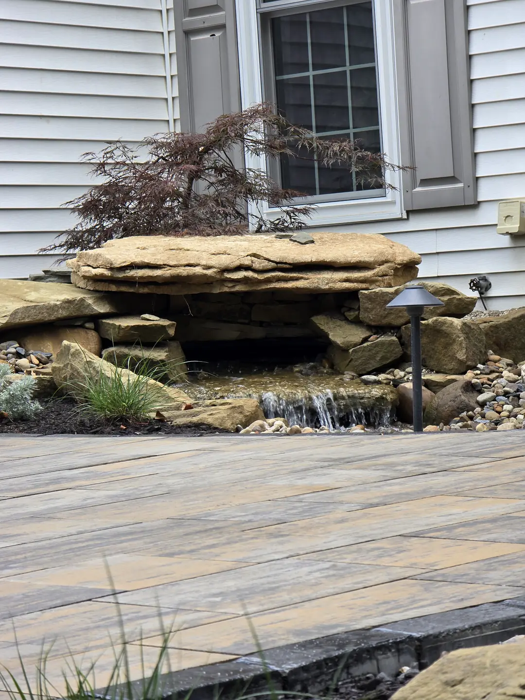 Landscape water feature and natural stone details at a Stow property