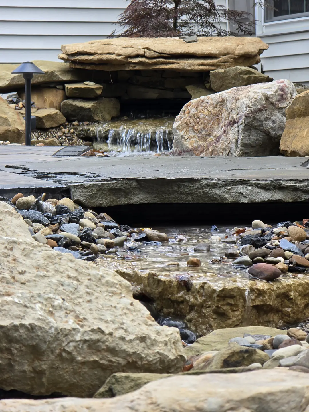 Landscape water feature and natural stone details at a Stow property