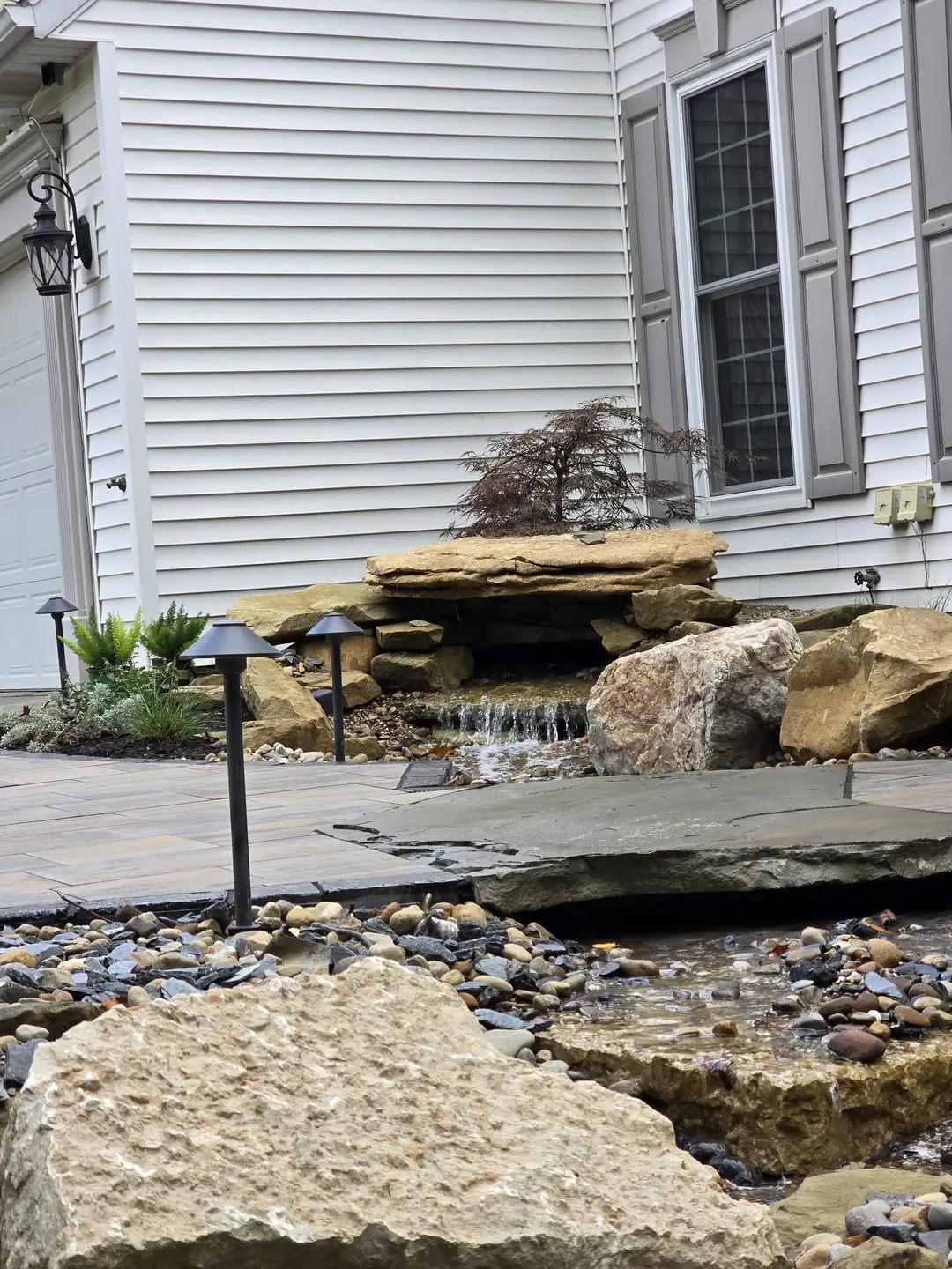 Landscape water feature and natural stone details at a Stow property