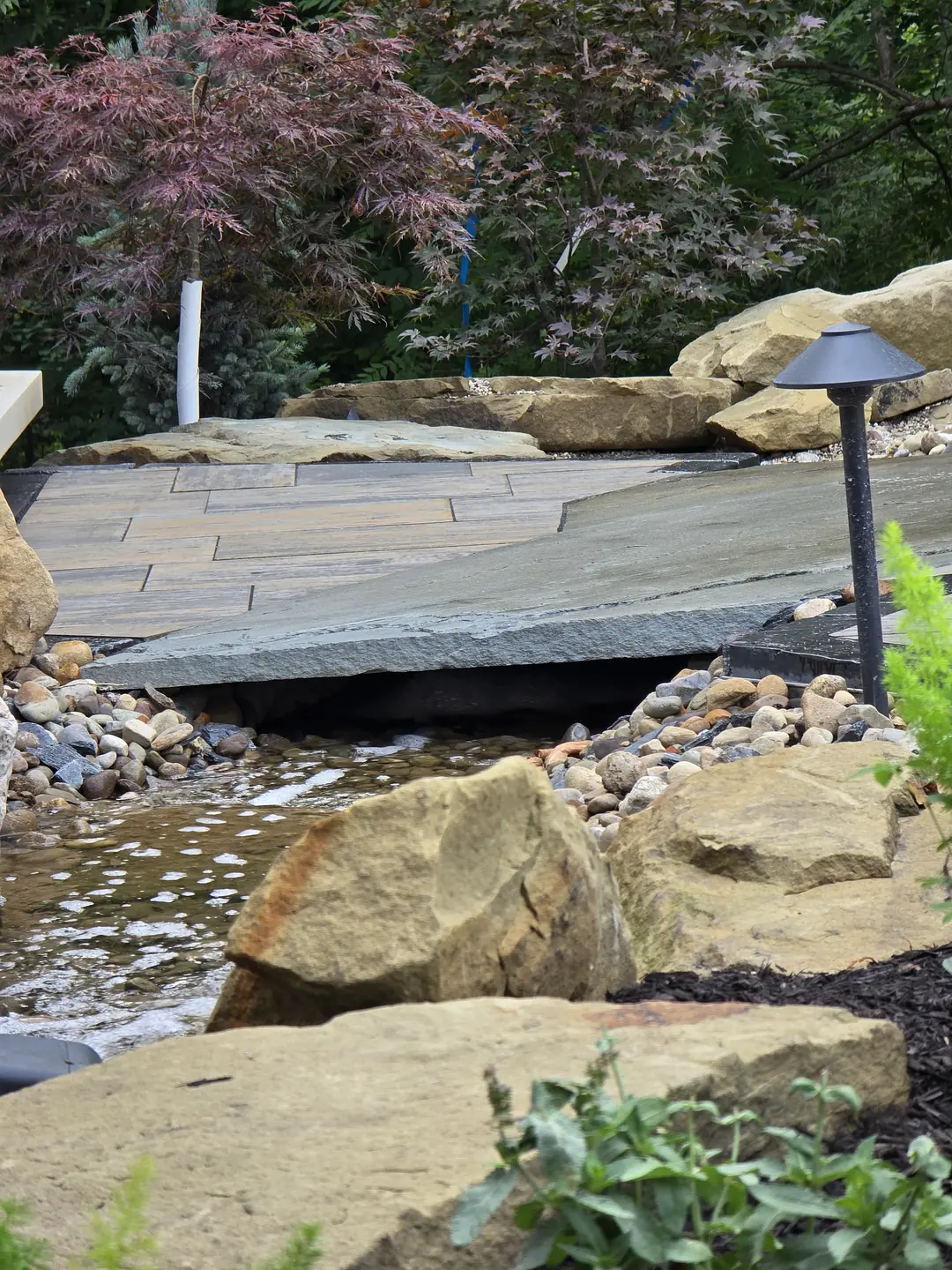 Landscape water feature and natural stone details at a Stow property