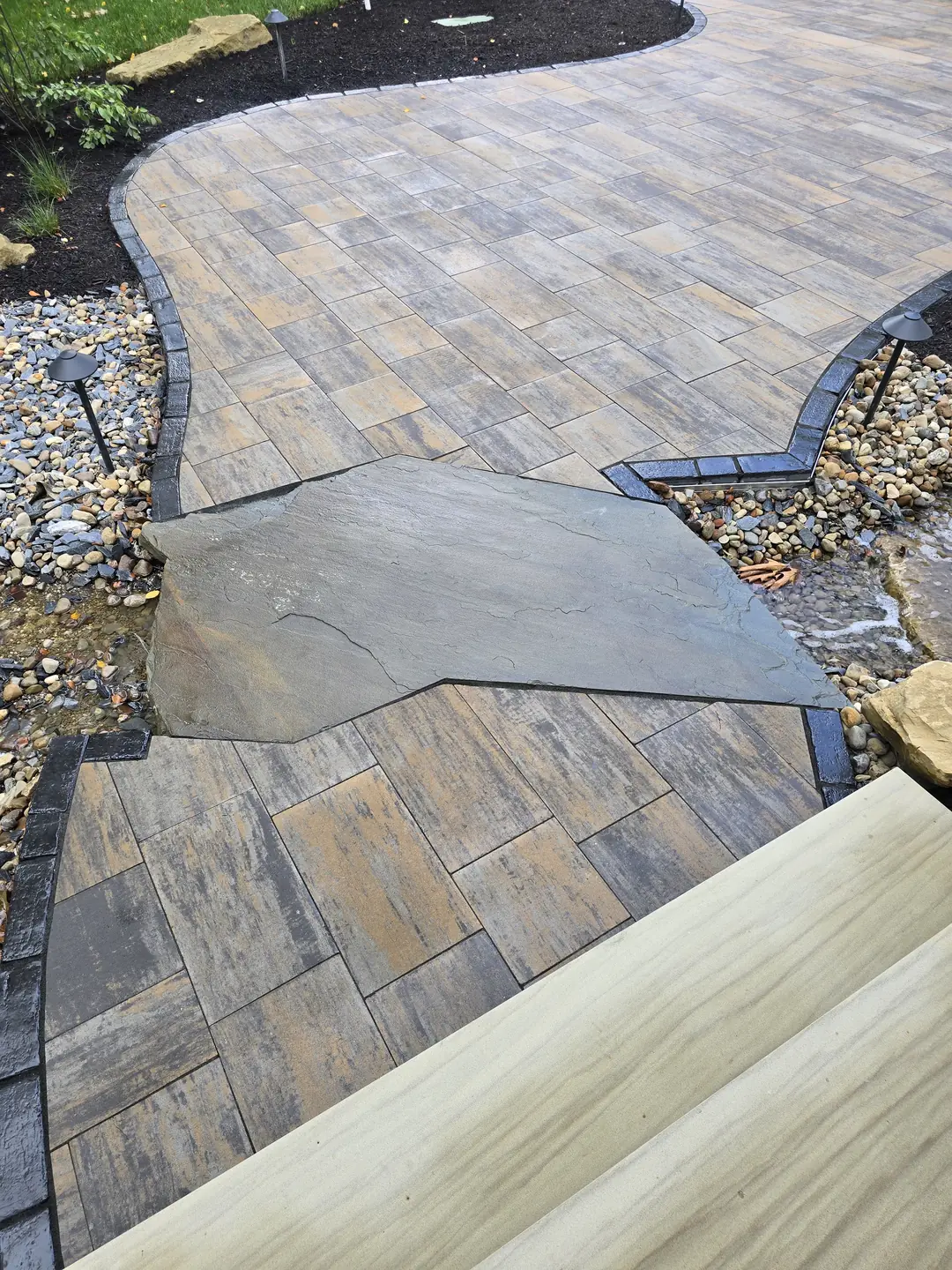 Landscape water feature and natural stone details at a Stow property