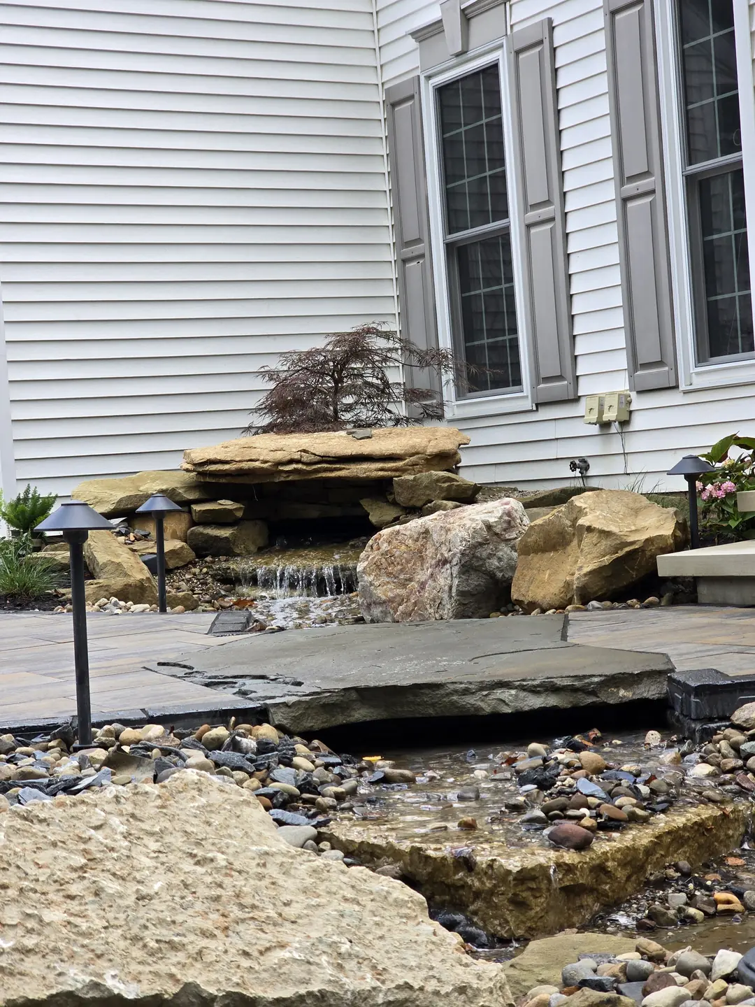 Landscape water feature and natural stone details at a Stow property