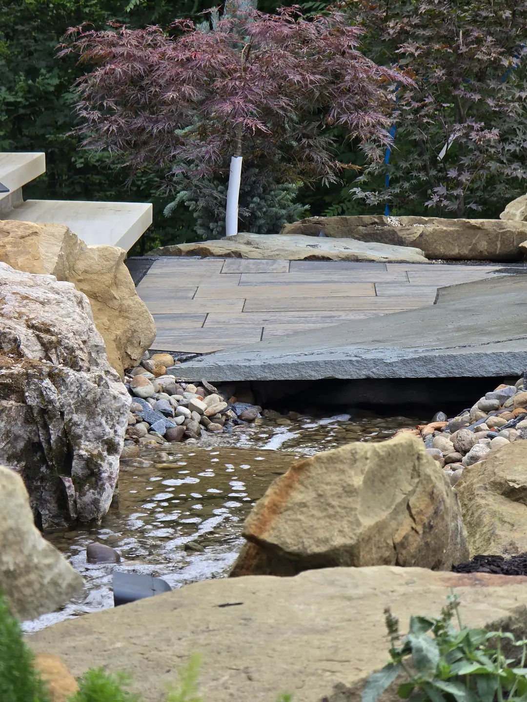 Landscape water feature and natural stone details at a Stow property