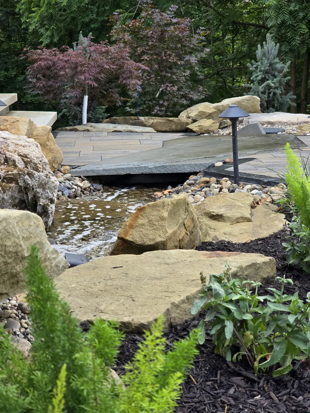 Landscape water feature and natural stone details at a Stow property