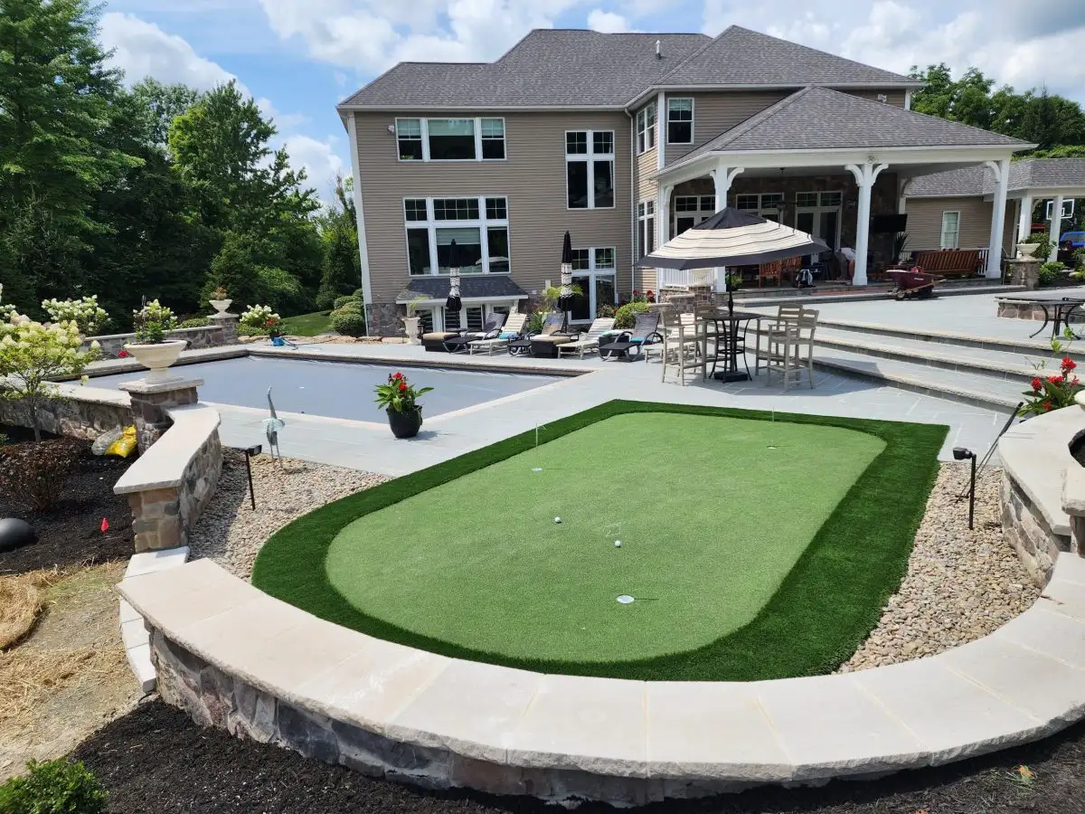 Putting green with pool and outdoor living area