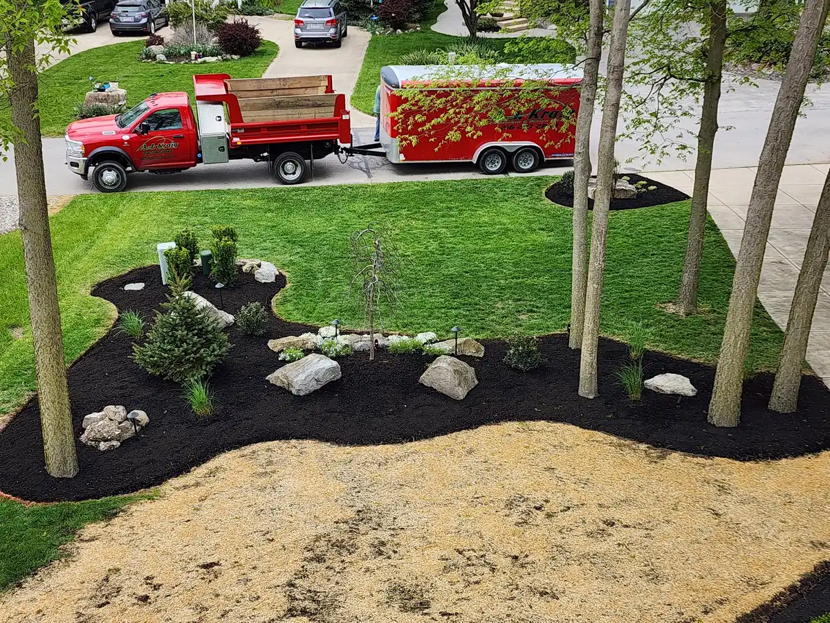 New landscape installation with mulch beds, shrubs, and decorative boulders