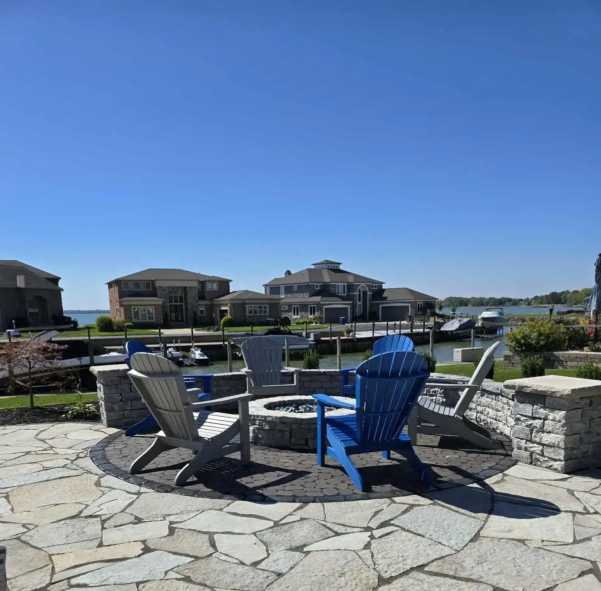 Lakefront fire pit patio with Adirondack chairs installed by A.J. Kraig in Marblehead Ohio