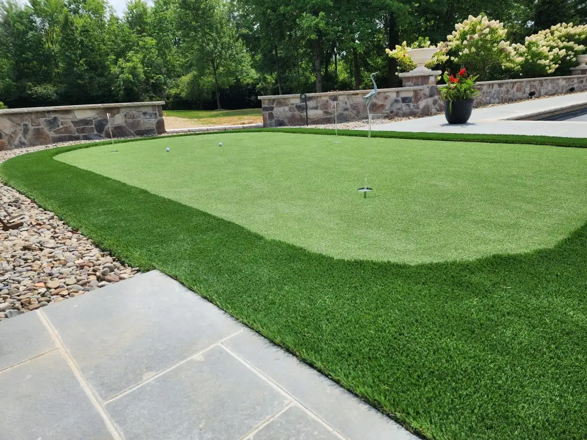 Putting green near stone wall with flowers